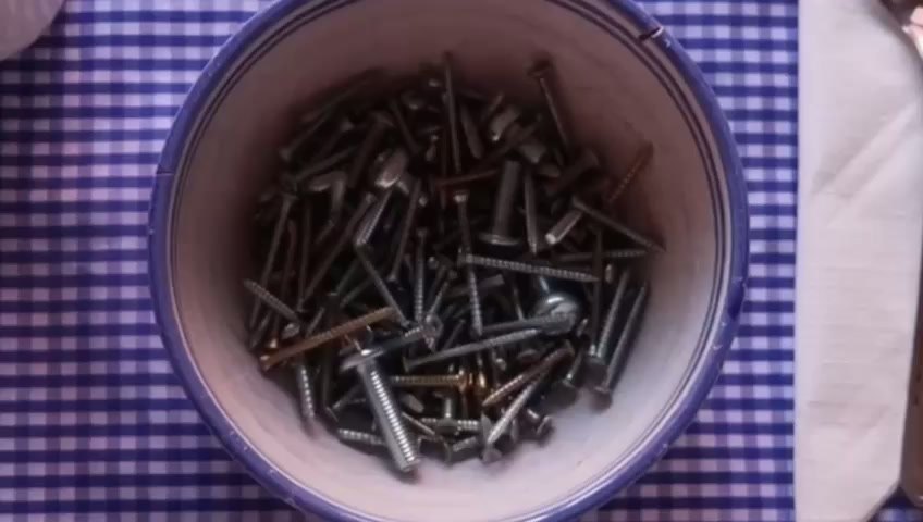Fotograma del videoarte Libre Albedrío: un cuenco lleno de tornillos sobre un mantel de cuadros